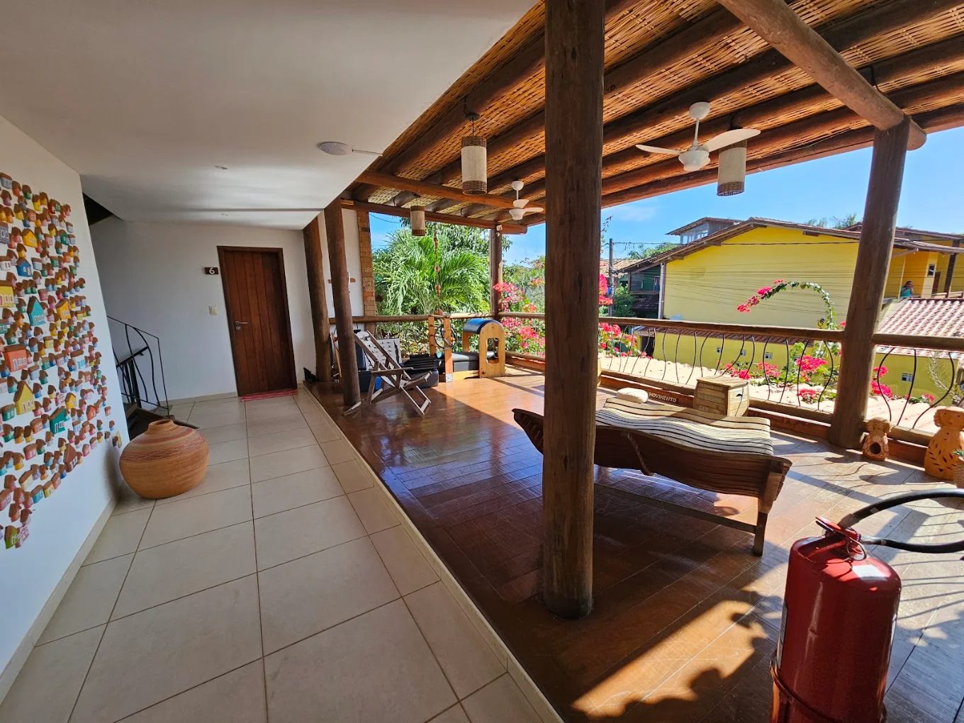 Terraço com espreguiçadeira, ventiladores e buganvílias